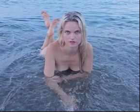 Blonde natural girl swimming naked in public beach